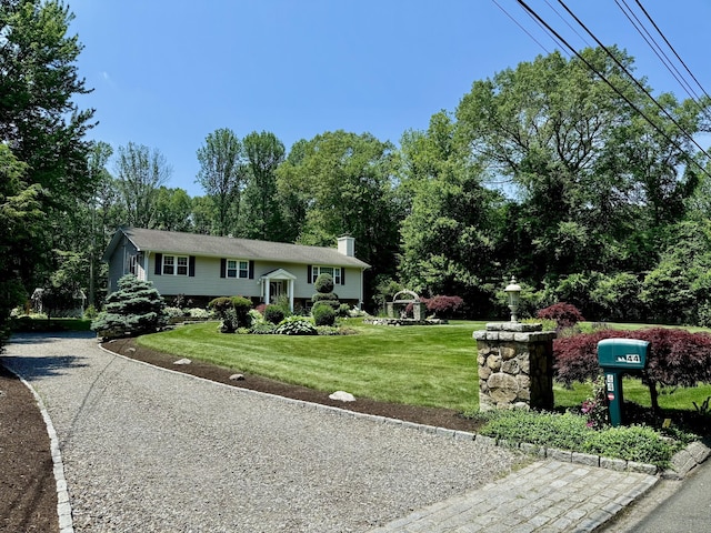 44 Fawn Hill Rd, Shelton, CT 06484 - raised ranch featuring a front lawn, a chimney, and view of scattered trees