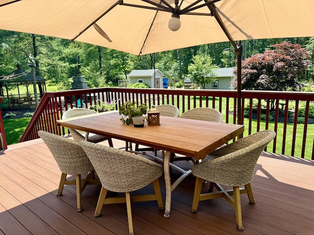 44 Fawn Hill Rd, Shelton, CT 06484 - wooden terrace with outdoor dining area, a storage unit, a gazebo, a lawn, and view of wooded area