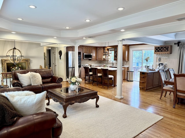 44 Fawn Hill Rd, Shelton, CT 06484 - living area with decorative columns, ornamental molding, light wood-type flooring, a tray ceiling, and recessed lighting