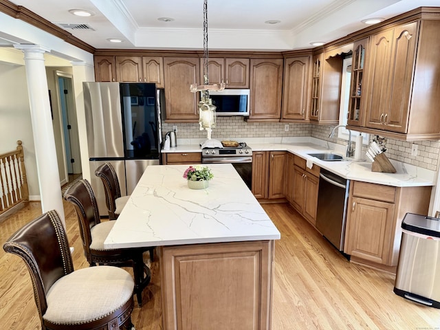 44 Fawn Hill Rd, Shelton, CT 06484 - kitchen with stainless steel appliances, light wood-type flooring, a center island, ornate columns, and ornamental molding
