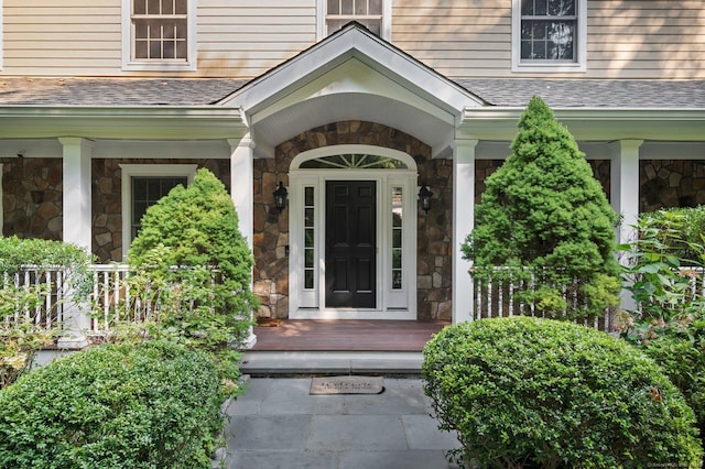 12B Hickory Dr, Greenwich, CT 06831 - doorway to property with stone siding, a shingled roof, and covered porch