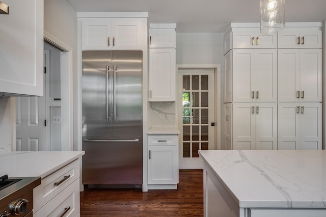12B Hickory Dr, Greenwich, CT 06831 - kitchen with high end fridge, dark wood-style flooring, white cabinets, light stone counters, and backsplash