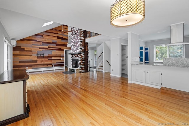 96 Pine Mountain Rd, Ridgefield, CT 06877 - unfurnished living room featuring stairway, wood walls, light wood-type flooring, and a high ceiling
