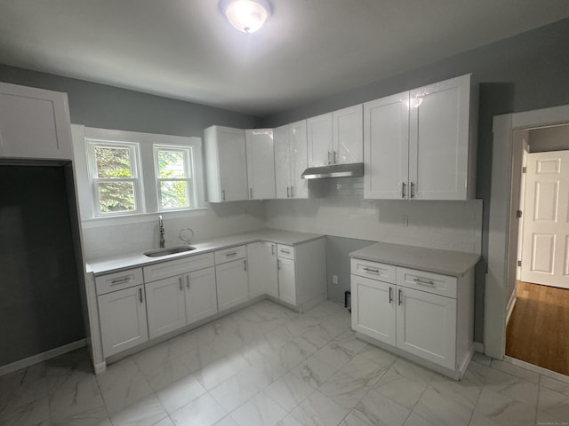 18 Pine St, Waterbury, CT 06710 - kitchen featuring light marble finish flooring, under cabinet range hood, backsplash, white cabinetry, and light countertops