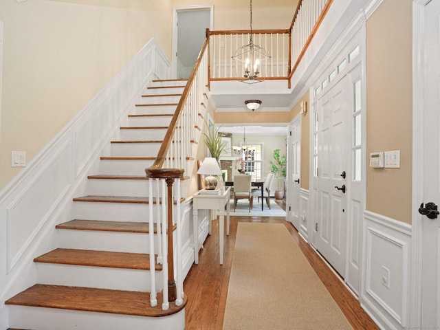 5 September Ln, Weston, CT 06883 - foyer with a chandelier, a decorative wall, stairway, wood finished floors, and a wainscoted wall