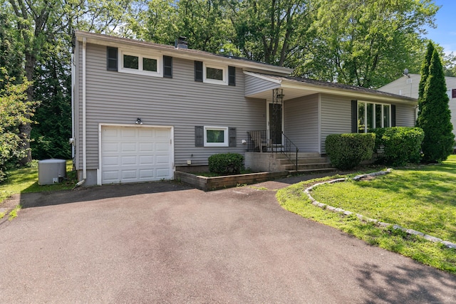 50 Carroll Rd, Hamden, CT 06517 - tri-level home with a garage, asphalt driveway, a front lawn, and a chimney
