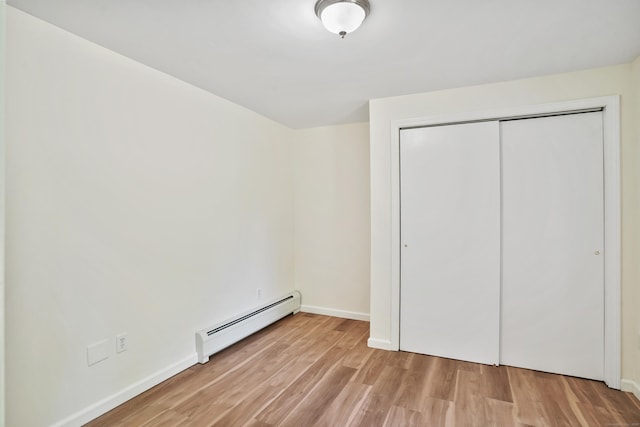 1198 New Haven Ave, Milford, CT 06460 - unfurnished bedroom with baseboard heating, light wood-style flooring, and a closet