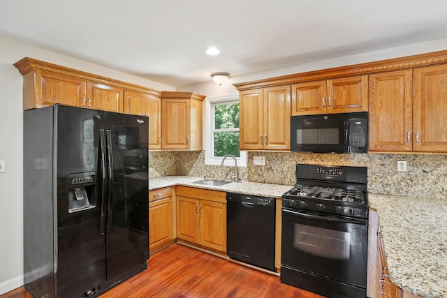 1198 New Haven Ave, Milford, CT 06460 - kitchen with black appliances, wood finished floors, tasteful backsplash, light stone counters, and recessed lighting