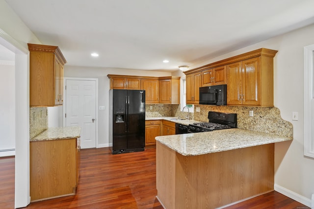 1198 New Haven Ave, Milford, CT 06460 - kitchen with black appliances, a peninsula, dark wood-style flooring, decorative backsplash, and light stone counters