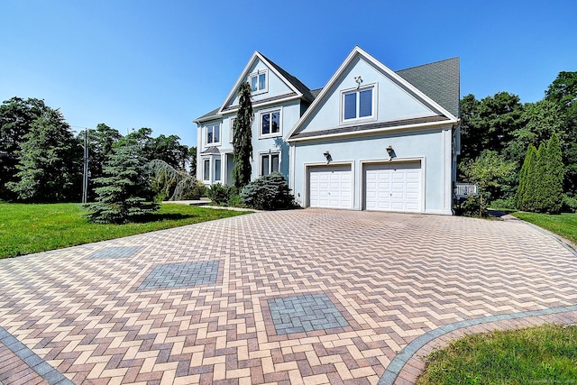 125 Waverly Dr, Newington, CT 06111 - view of front of home with decorative driveway, a garage, a front yard, and stucco siding