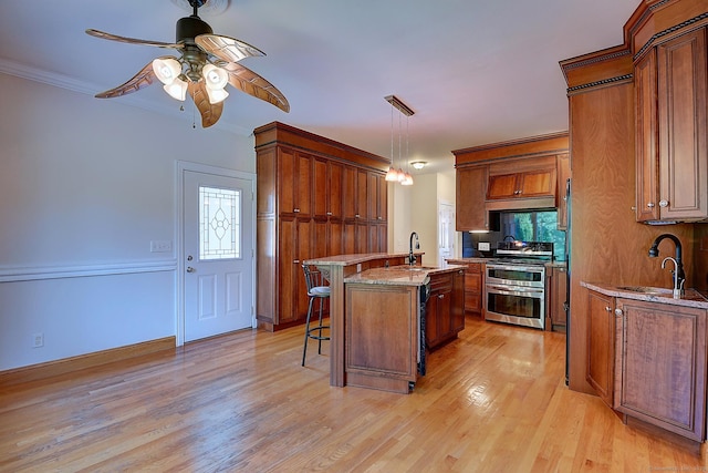 125 Waverly Dr, Newington, CT 06111 - kitchen with range with two ovens, a breakfast bar, light wood-style flooring, an island with sink, and healthy amount of natural light