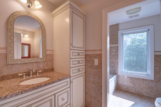 125 Waverly Dr, Newington, CT 06111 - bathroom featuring tile walls, vanity, a tub, and a wainscoted wall