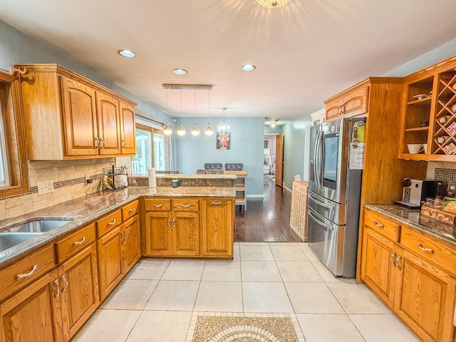 143 Soundview Ave, Shelton, CT 06484 - kitchen featuring stainless steel refrigerator with ice dispenser, a peninsula, brown cabinetry, recessed lighting, and backsplash