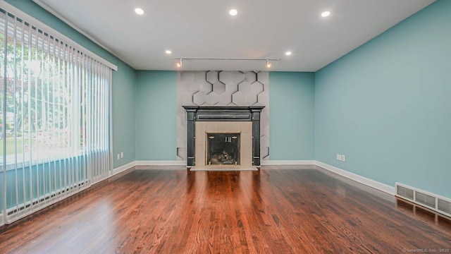 143 Soundview Ave, Shelton, CT 06484 - unfurnished living room with a tiled fireplace, wood finished floors, recessed lighting, and rail lighting