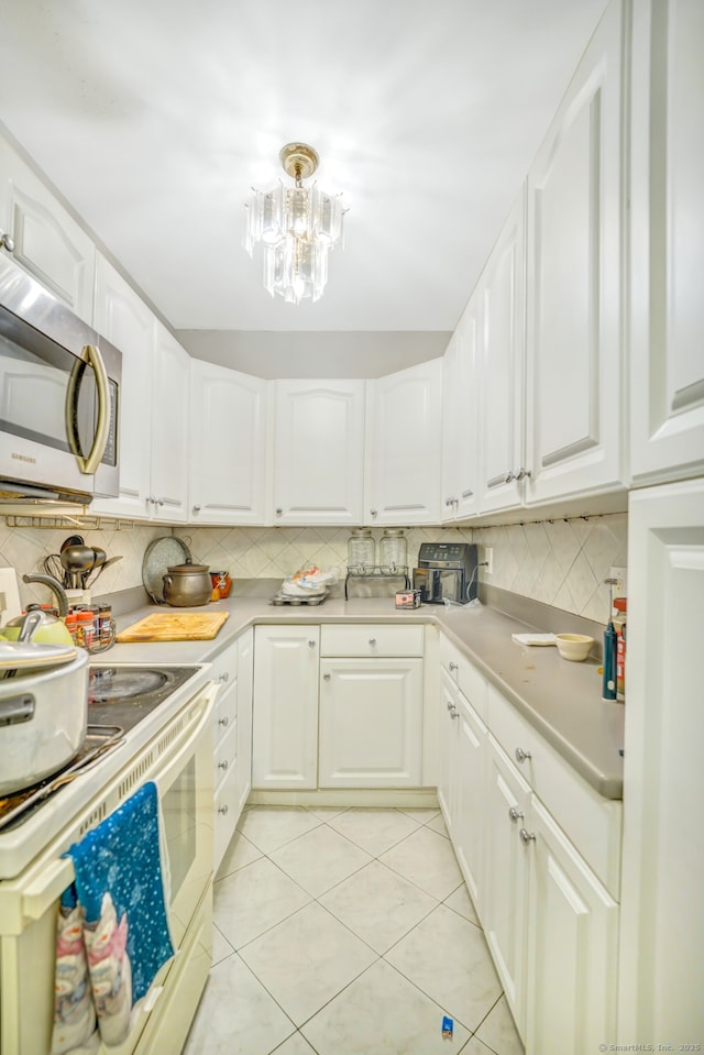 350 S Main St, Naugatuck, CT 06770 - kitchen with stainless steel microwave, white electric range, backsplash, light tile patterned floors, and light countertops
