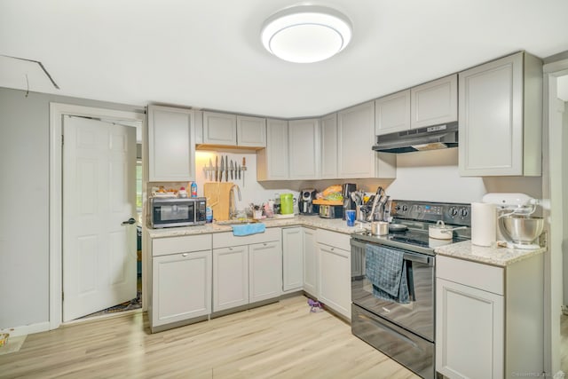 350 S Main St, Naugatuck, CT 06770 - kitchen with black range with electric cooktop, under cabinet range hood, stainless steel microwave, and light wood-type flooring