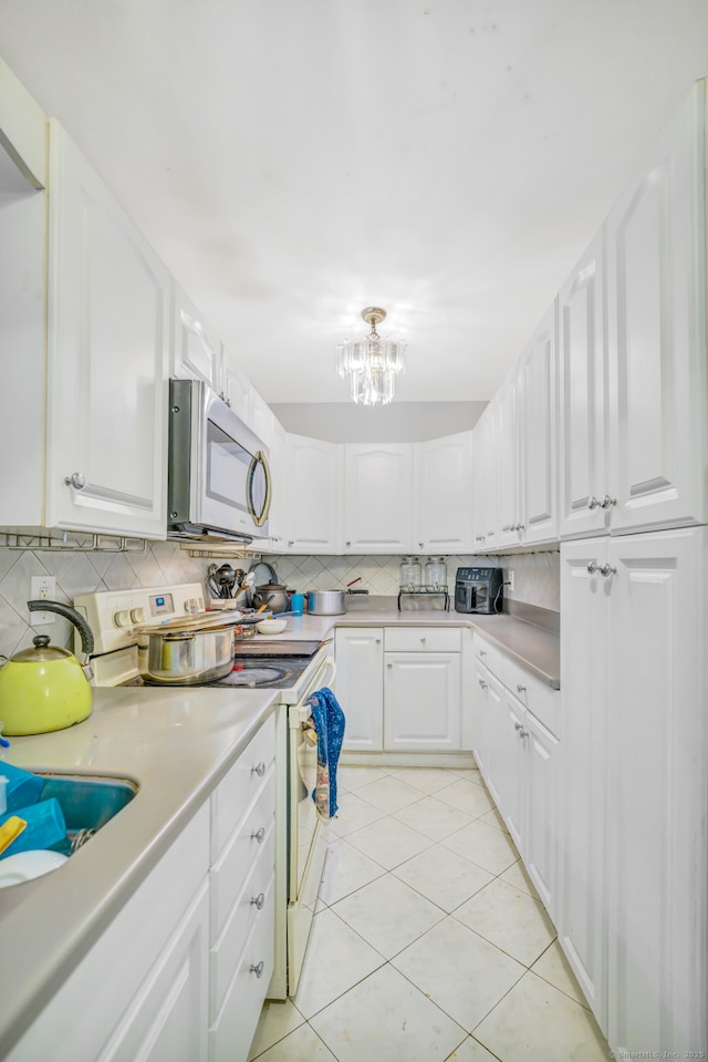 350 S Main St, Naugatuck, CT 06770 - kitchen with white range with electric stovetop, stainless steel microwave, decorative backsplash, a chandelier, and light countertops