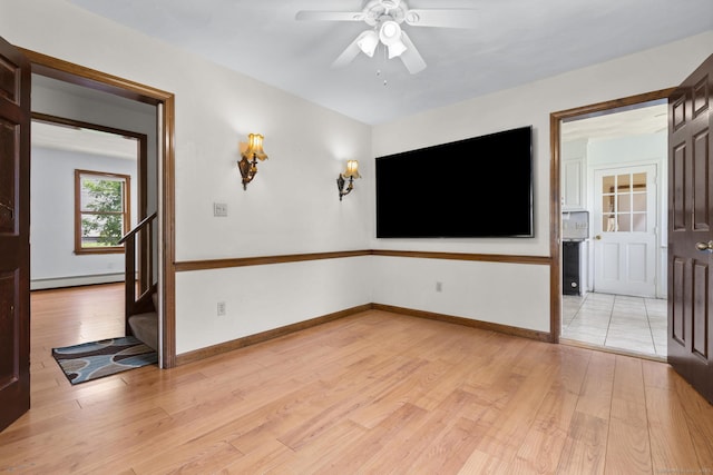 27 Homestead St, Manchester, CT 06042 - empty room featuring baseboard heating, stairway, light wood finished floors, and a ceiling fan