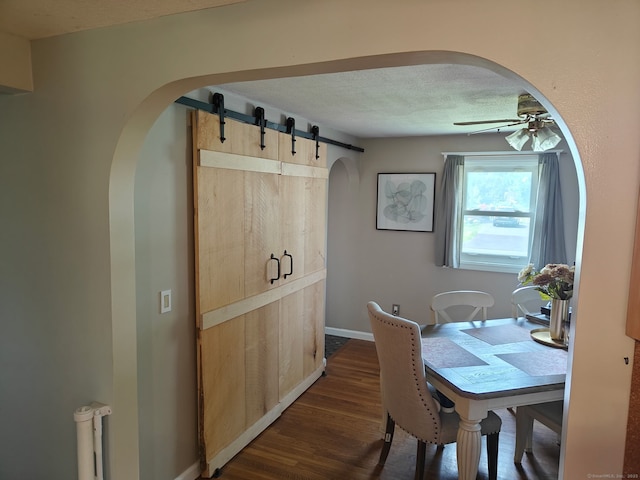 42 Meadowlark Rd, Enfield, CT 06082 - dining area with arched walkways, ceiling fan, dark wood-style flooring, and a textured ceiling