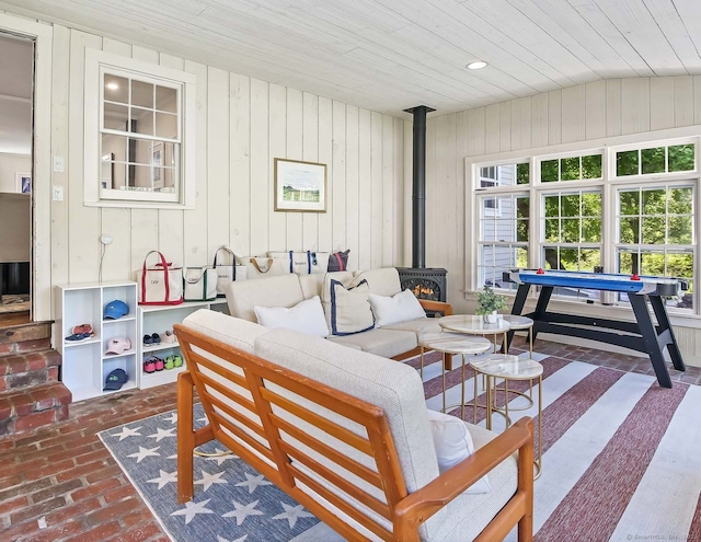 52 Wilton Rd E, Ridgefield, CT 06877 - living room featuring wooden ceiling, brick floors, a wood stove, wooden walls, and recessed lighting