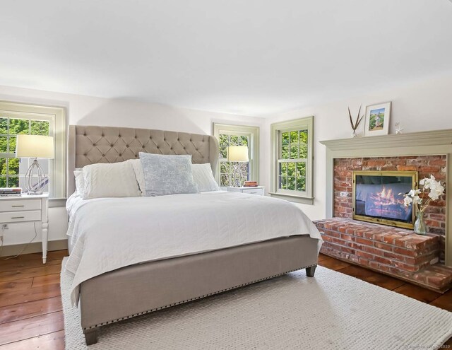 52 Wilton Rd E, Ridgefield, CT 06877 - bedroom with hardwood / wood-style floors, multiple windows, and a brick fireplace