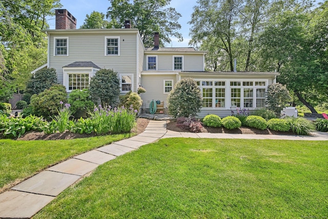 52 Wilton Rd E, Ridgefield, CT 06877 - view of front of house with a chimney, a front lawn, and a sunroom