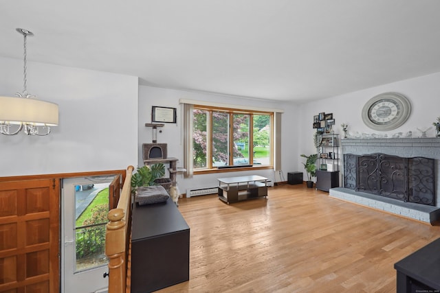 59 Litchfield Ln, Bristol, CT 06010 - living area with baseboard heating, a chandelier, a fireplace, and wood finished floors