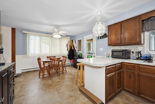 59 Litchfield Ln, Bristol, CT 06010 - kitchen featuring a peninsula, light countertops, ceiling fan, black microwave, and hanging light fixtures
