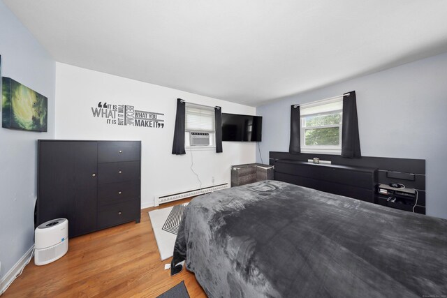59 Litchfield Ln, Bristol, CT 06010 - bedroom featuring a baseboard radiator, light wood-type flooring, and cooling unit