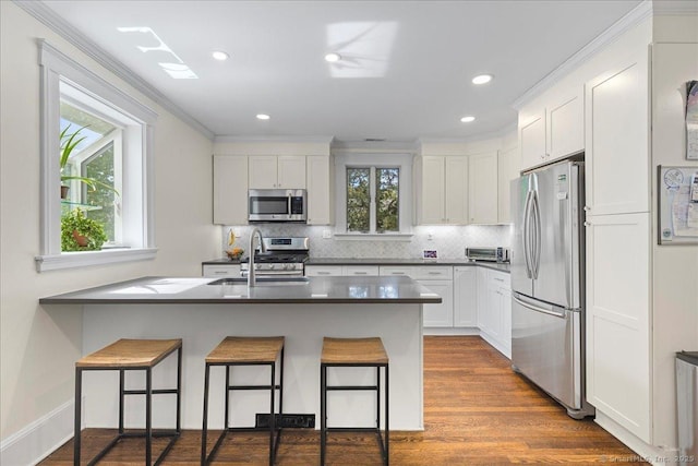 203 Ridgewood Ave, Hamden, CT 06517 - kitchen featuring stainless steel appliances, backsplash, a kitchen breakfast bar, white cabinetry, and ornamental molding