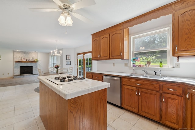 119 NW Dr, Plainville, CT 06062 - kitchen with white gas stovetop, stainless steel dishwasher, a center island, brown cabinets, and a brick fireplace