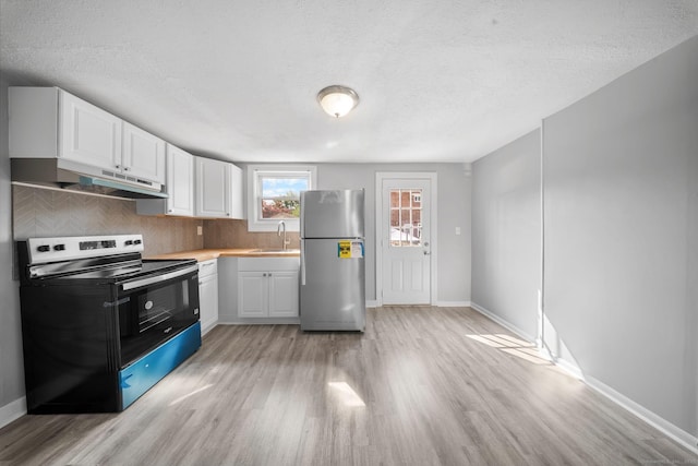 110 Asylum St, Bridgeport, CT 06610 - kitchen with freestanding refrigerator, electric stove, under cabinet range hood, light wood-style flooring, and white cabinetry