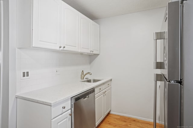 4 Union Ave Apt 30, Norwalk, CT 06851 - kitchen featuring stainless steel dishwasher, freestanding refrigerator, light wood-style floors, white cabinets, and tasteful backsplash