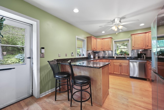 98 Aetna Ave, Torrington, CT 06790 - kitchen with stainless steel appliances, a peninsula, a kitchen breakfast bar, ceiling fan, and light wood-style floors