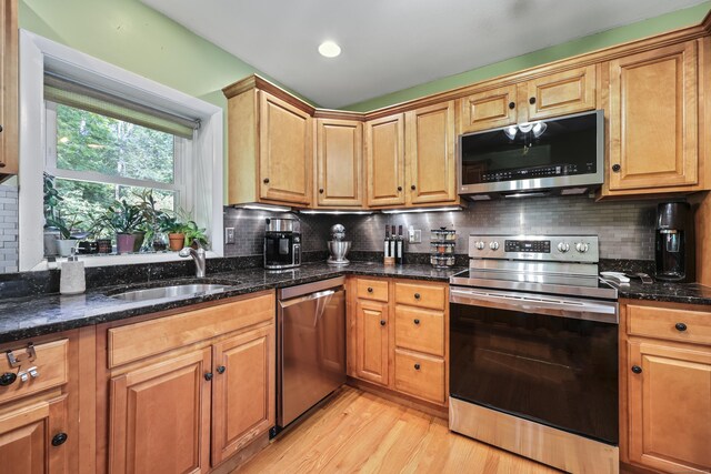 98 Aetna Ave, Torrington, CT 06790 - kitchen with stainless steel appliances, light wood-style flooring, decorative backsplash, and dark stone counters