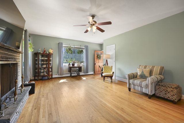 98 Aetna Ave, Torrington, CT 06790 - sitting room featuring a baseboard heating unit, a brick fireplace, wood finished floors, and a ceiling fan