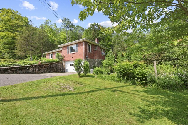 98 Aetna Ave, Torrington, CT 06790 - view of property exterior featuring a chimney, driveway, brick siding, a garage, and a yard