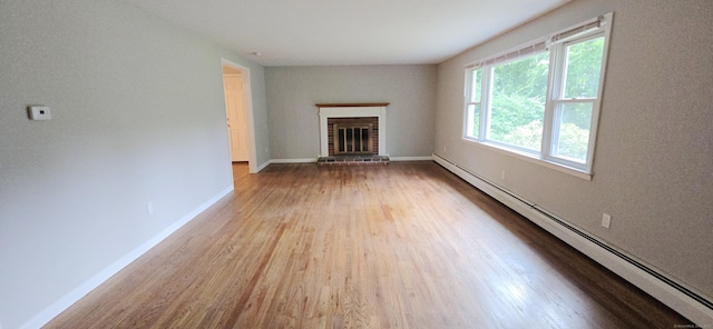159 Windsorville Rd, South Windsor, CT 06074 - unfurnished living room featuring a baseboard heating unit, wood finished floors, and a fireplace