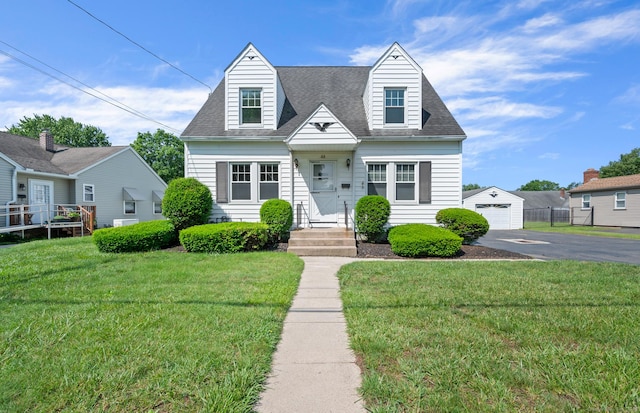32 Franklin St, Southington, CT 06479 - cape cod home featuring a front yard, a detached garage, driveway, and an outbuilding