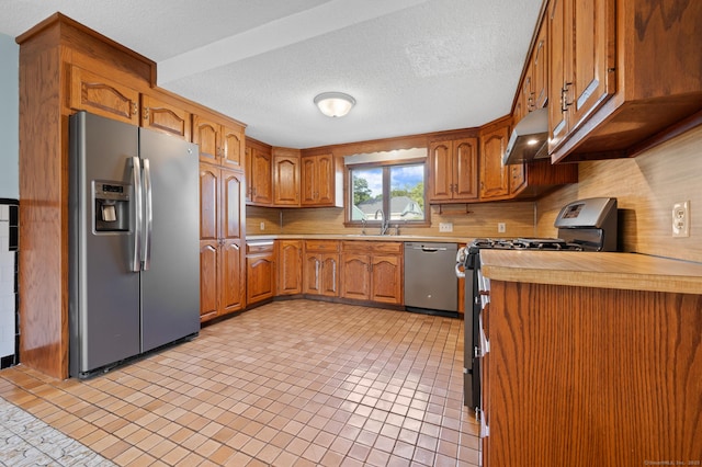 32 Franklin St, Southington, CT 06479 - kitchen with appliances with stainless steel finishes, light countertops, brown cabinets, range hood, and tasteful backsplash