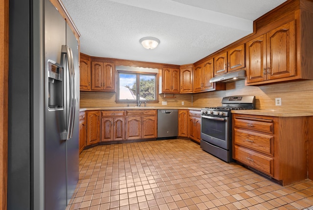 32 Franklin St, Southington, CT 06479 - kitchen with appliances with stainless steel finishes, under cabinet range hood, brown cabinetry, light countertops, and a textured ceiling