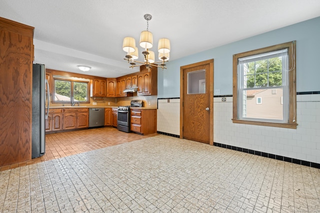 32 Franklin St, Southington, CT 06479 - kitchen with stainless steel appliances, brown cabinetry, light countertops, a chandelier, and plenty of natural light