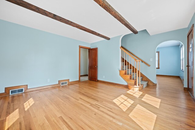 32 Franklin St, Southington, CT 06479 - unfurnished living room featuring arched walkways, beam ceiling, light wood finished floors, and stairway