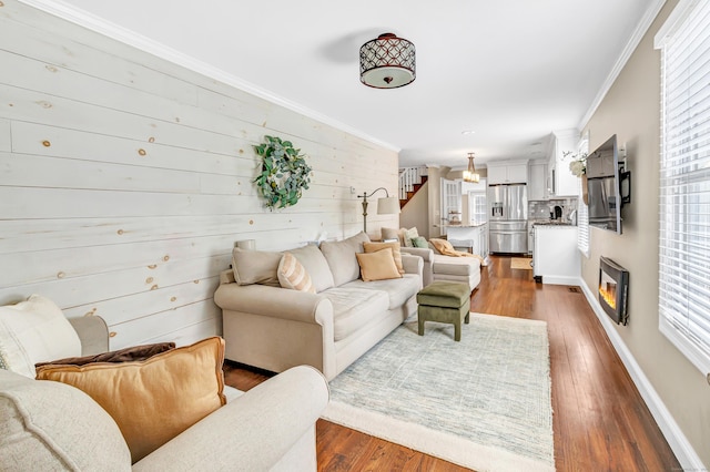 131 Long Hill Cross Rd, Shelton, CT 06484 - living room featuring plenty of natural light, crown molding, dark wood finished floors, wood walls, and stairs