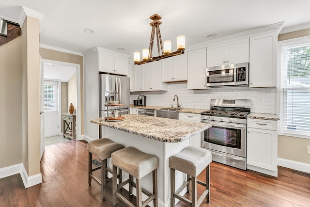 131 Long Hill Cross Rd, Shelton, CT 06484 - kitchen featuring stainless steel appliances, a breakfast bar, decorative backsplash, white cabinets, and ornamental molding