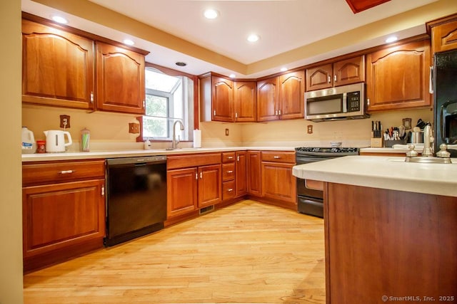 23 Church St, Plainville, CT 06062 - kitchen featuring stainless steel appliances, light wood-style floors, brown cabinetry, light countertops, and recessed lighting