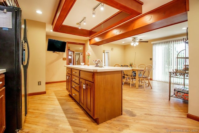 23 Church St, Plainville, CT 06062 - kitchen featuring black fridge, light wood-style floors, a ceiling fan, brown cabinets, and light countertops