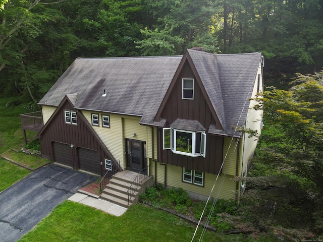 166 S Main St, Marlborough, CT 06447 - a-frame style home with board and batten siding, driveway, a view of trees, and an attached garage