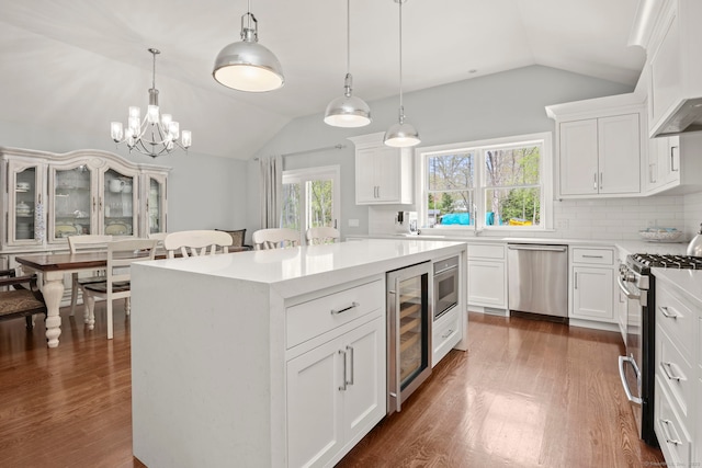 24 Appletree Ln, Norwalk, CT 06850 - kitchen with stainless steel appliances, vaulted ceiling, wine cooler, a center island, and light countertops