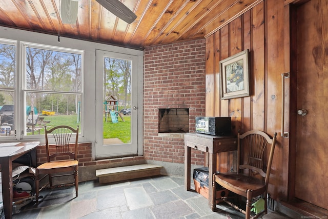 24 Appletree Ln, Norwalk, CT 06850 - sitting room featuring wooden ceiling, stone tile flooring, wooden walls, and brick wall